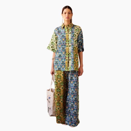 Woman wearing Mosaic Muse linen blend co-ord set with colourful patchwork print shirt and wide-leg trousers.